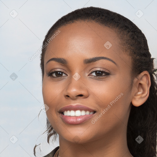 Joyful black young-adult female with long  brown hair and brown eyes