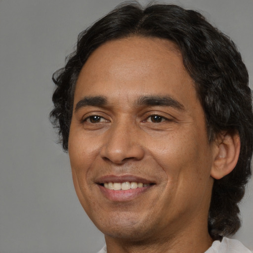 Joyful latino adult male with short  brown hair and brown eyes