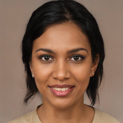 Joyful black young-adult female with medium  brown hair and brown eyes