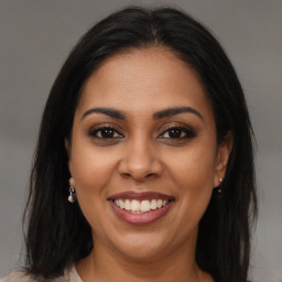 Joyful latino young-adult female with long  brown hair and brown eyes