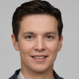 Joyful white young-adult male with short  brown hair and grey eyes