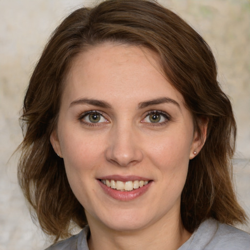 Joyful white young-adult female with medium  brown hair and green eyes