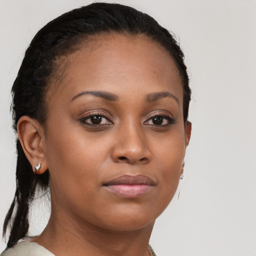 Joyful black young-adult female with long  brown hair and brown eyes