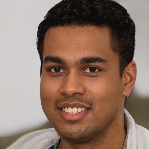 Joyful latino young-adult male with short  black hair and brown eyes