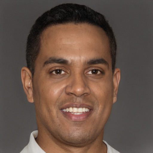 Joyful black young-adult male with short  brown hair and brown eyes