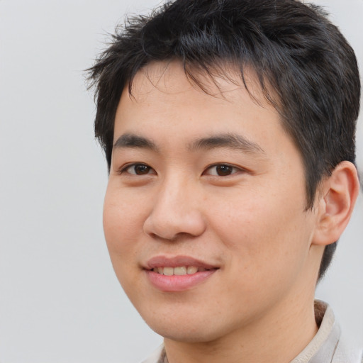 Joyful asian young-adult male with short  brown hair and brown eyes