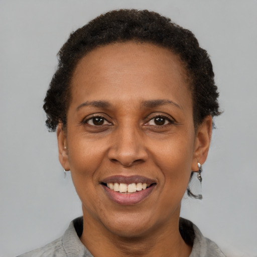 Joyful black adult female with short  brown hair and brown eyes