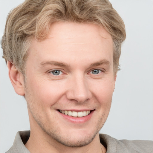 Joyful white adult male with short  brown hair and blue eyes