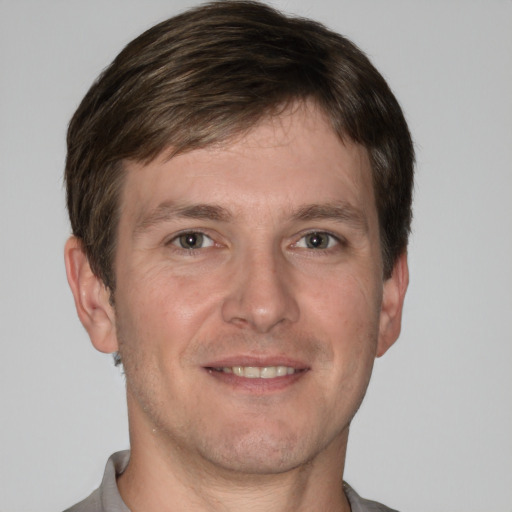 Joyful white adult male with short  brown hair and grey eyes