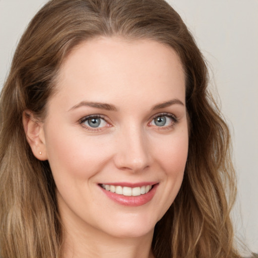 Joyful white young-adult female with long  brown hair and green eyes