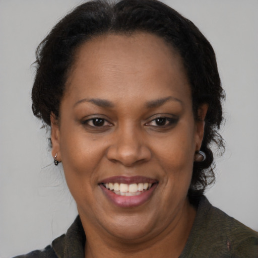 Joyful black adult female with medium  brown hair and brown eyes