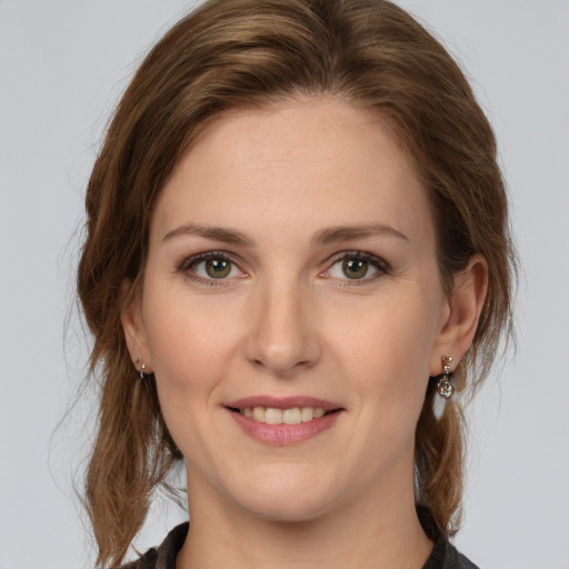 Joyful white young-adult female with medium  brown hair and green eyes