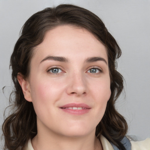 Joyful white young-adult female with medium  brown hair and grey eyes