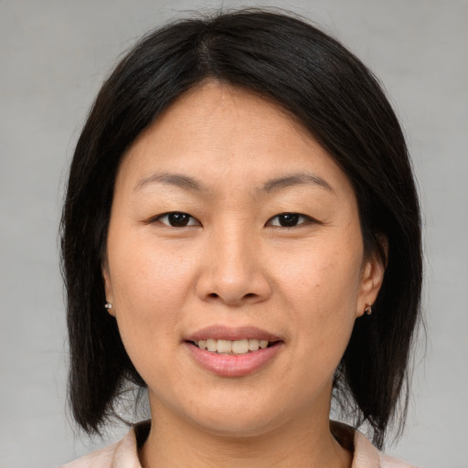 Joyful asian young-adult female with medium  brown hair and brown eyes