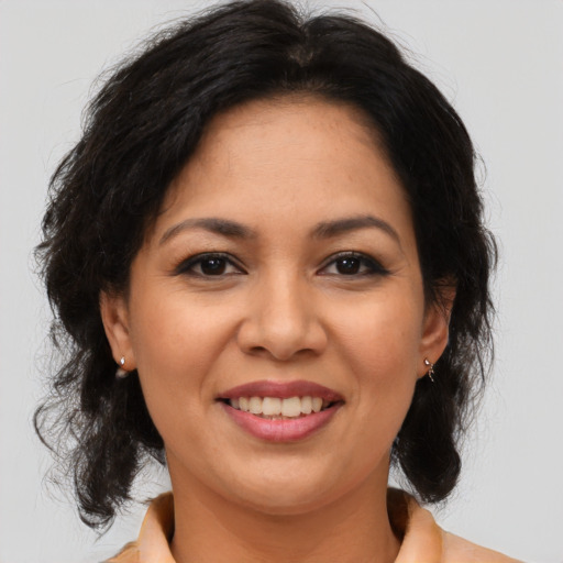 Joyful latino adult female with medium  brown hair and brown eyes