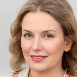 Joyful white adult female with medium  brown hair and blue eyes