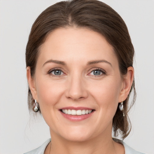 Joyful white adult female with medium  brown hair and grey eyes