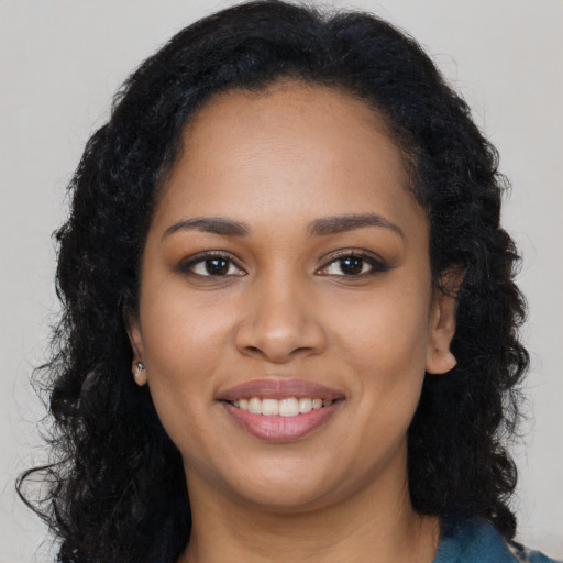Joyful black young-adult female with long  black hair and brown eyes