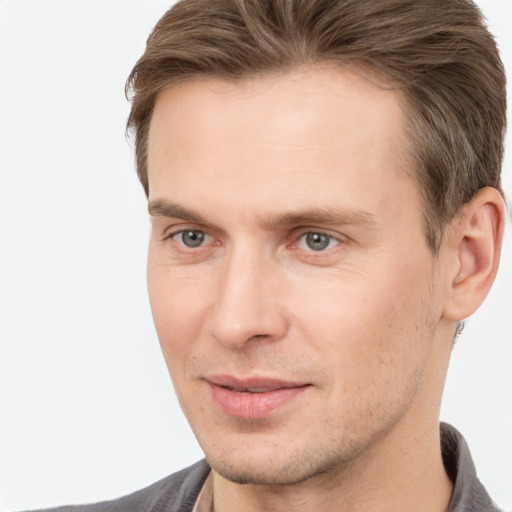 Joyful white young-adult male with short  brown hair and grey eyes