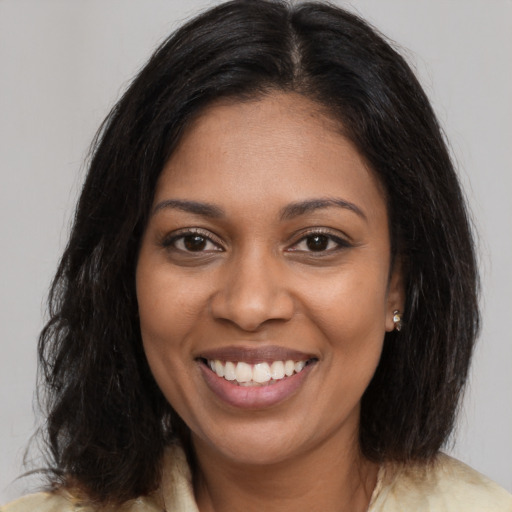 Joyful black young-adult female with medium  brown hair and brown eyes