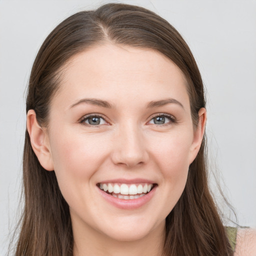 Joyful white young-adult female with long  brown hair and grey eyes