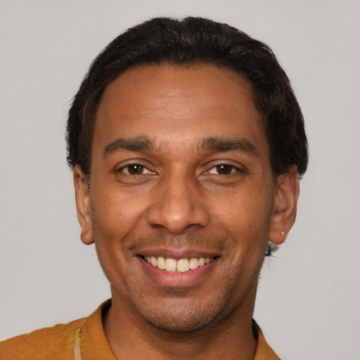 Joyful latino young-adult male with short  black hair and brown eyes