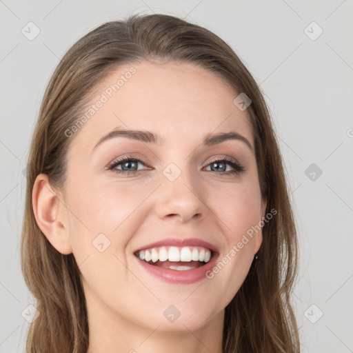 Joyful white young-adult female with long  brown hair and blue eyes