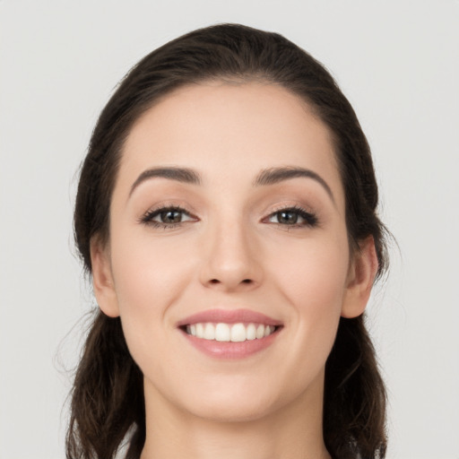 Joyful white young-adult female with long  brown hair and brown eyes