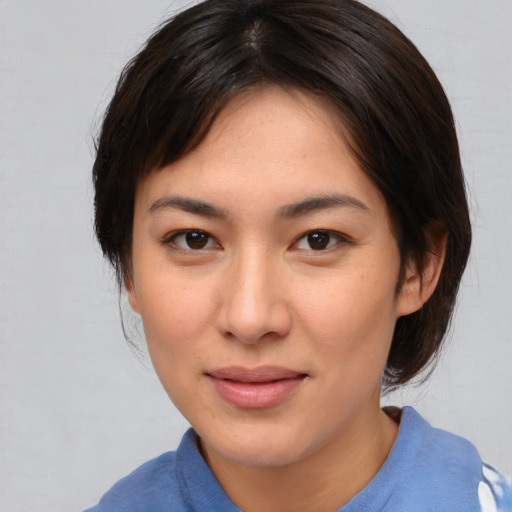 Joyful asian young-adult female with medium  brown hair and brown eyes