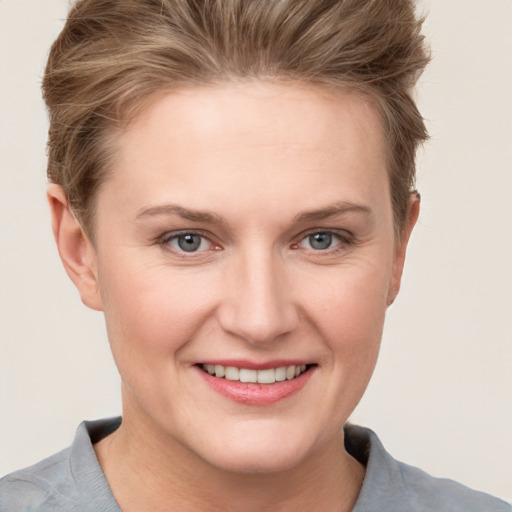 Joyful white young-adult female with short  brown hair and grey eyes