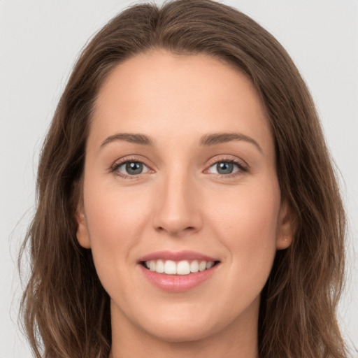 Joyful white young-adult female with long  brown hair and grey eyes