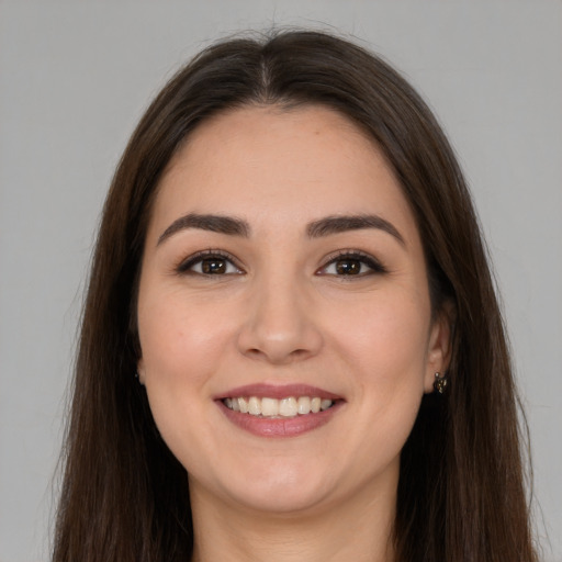 Joyful white young-adult female with long  brown hair and brown eyes