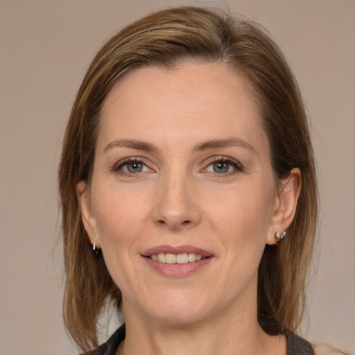 Joyful white adult female with medium  brown hair and grey eyes