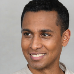 Joyful latino adult male with short  brown hair and brown eyes