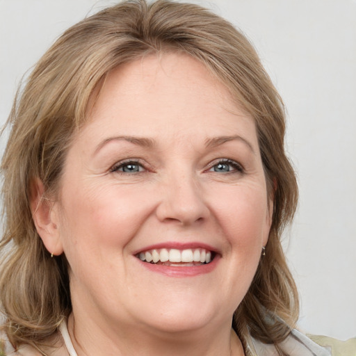 Joyful white adult female with medium  brown hair and blue eyes