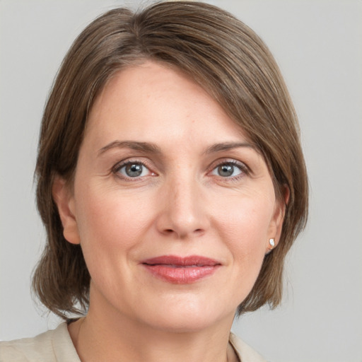 Joyful white adult female with medium  brown hair and grey eyes