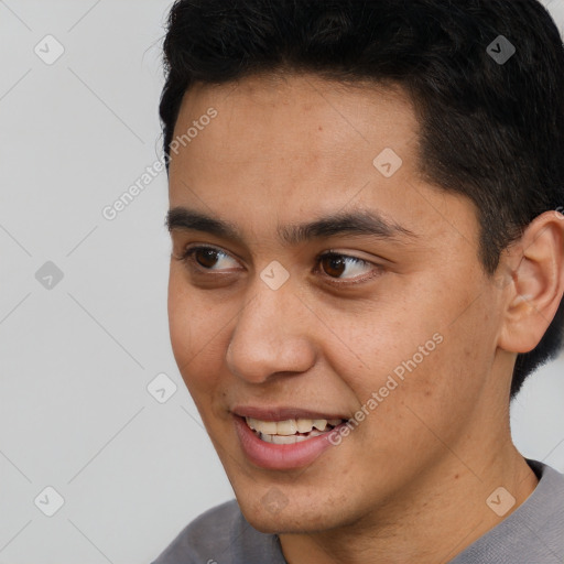 Joyful latino young-adult male with short  brown hair and brown eyes