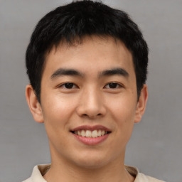 Joyful asian young-adult male with short  brown hair and brown eyes