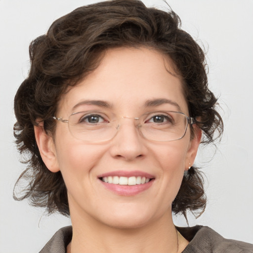 Joyful white adult female with medium  brown hair and grey eyes