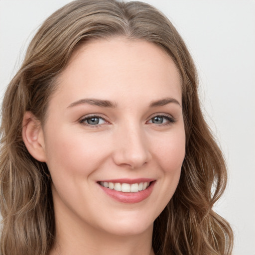 Joyful white young-adult female with long  brown hair and grey eyes