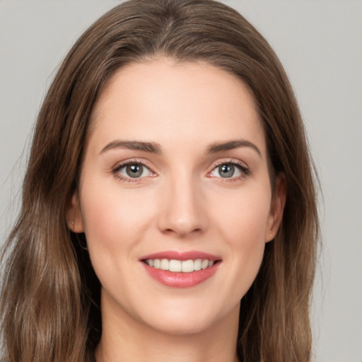 Joyful white young-adult female with long  brown hair and green eyes