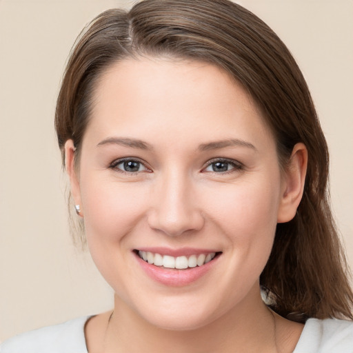 Joyful white young-adult female with medium  brown hair and grey eyes