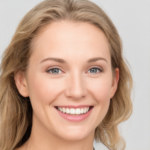 Joyful white young-adult female with long  brown hair and blue eyes