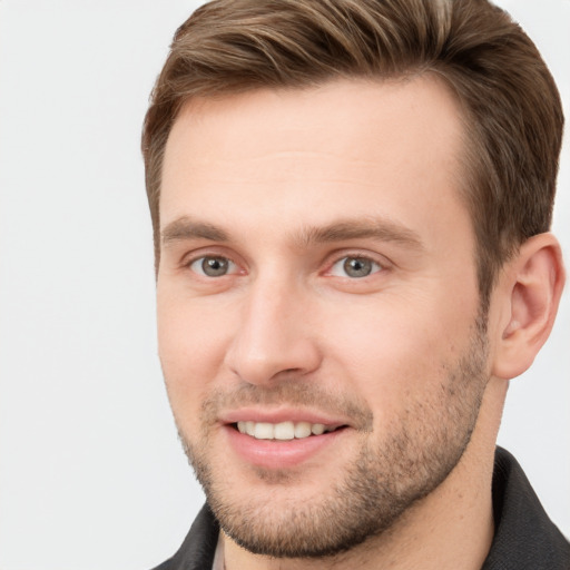 Joyful white young-adult male with short  brown hair and grey eyes