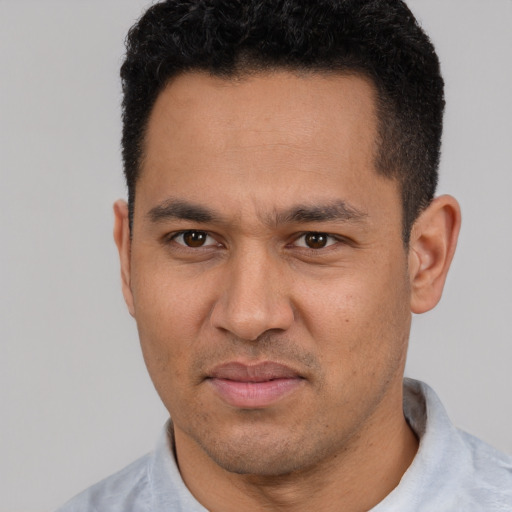 Joyful white young-adult male with short  black hair and brown eyes