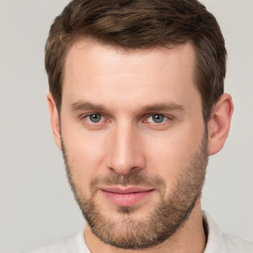 Joyful white young-adult male with short  brown hair and grey eyes