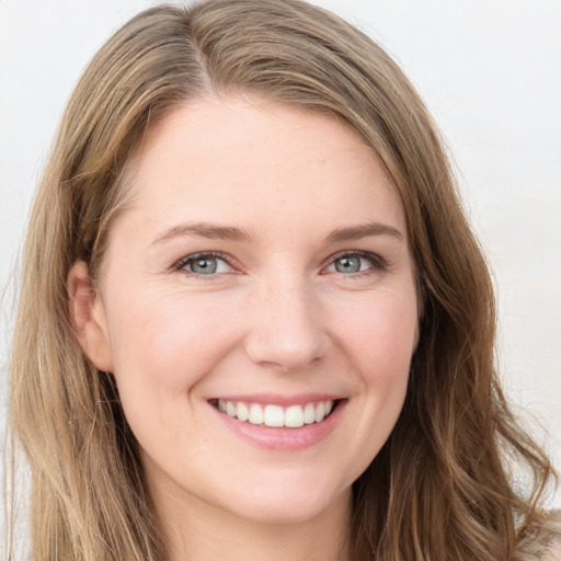 Joyful white young-adult female with long  brown hair and blue eyes