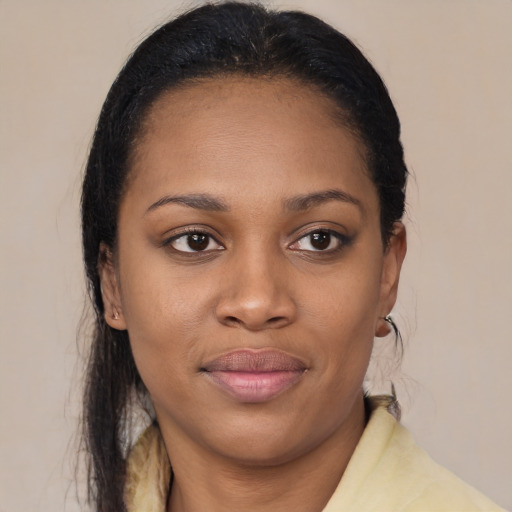 Joyful black young-adult female with long  black hair and brown eyes