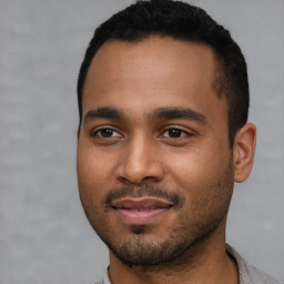 Joyful black young-adult male with short  black hair and brown eyes