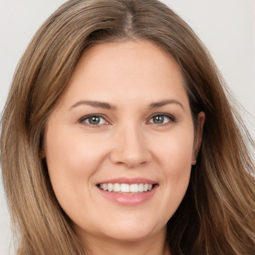 Joyful white young-adult female with long  brown hair and brown eyes